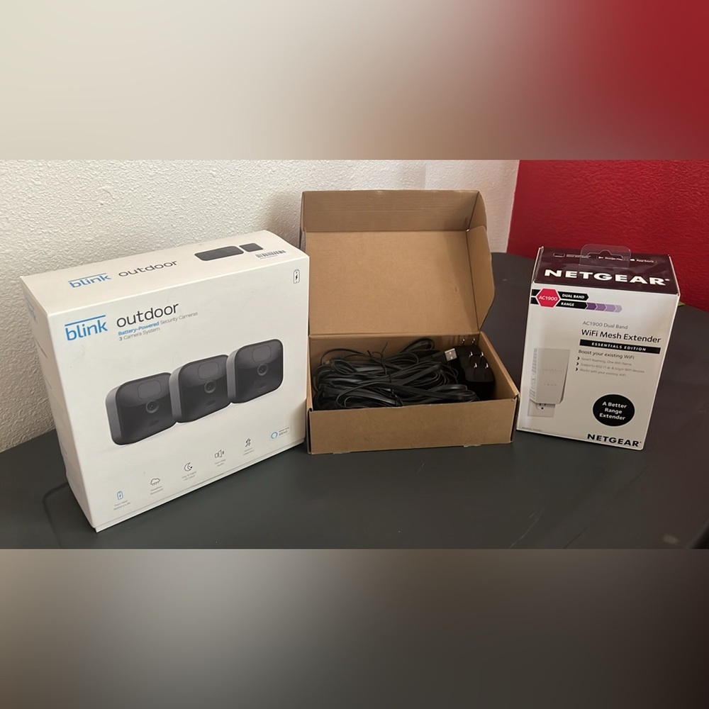Blink outdoor cameras with cords and a WiFi extender.